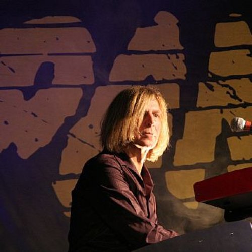 Portrait von Ritchie Barton auf der Bühne am Keyboard vor dem großen Pankow-Logo im Hintergrund